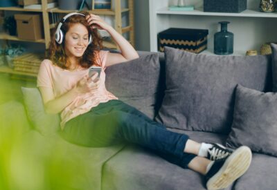 Une jeune femme ecoutant de la musique avec un smartphone.